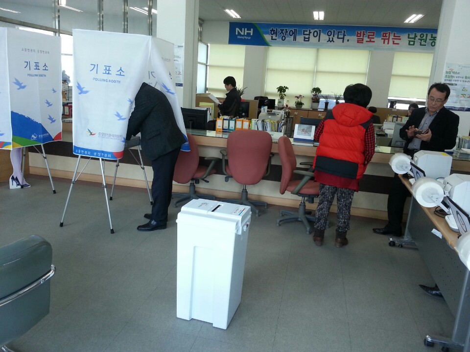 모의 투표용지를 받은 체험 참가자가 기표소에 들어가 기표를 하고 있는 모습