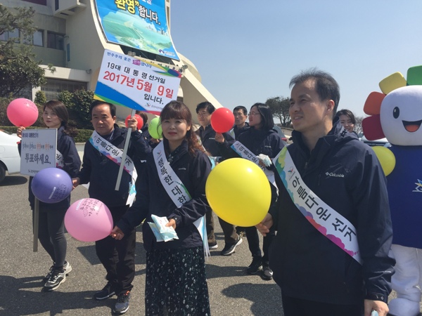 선관위 관계자들이 풍선을 들고 벚꽃 축제행사장에서 홍보하는 모습