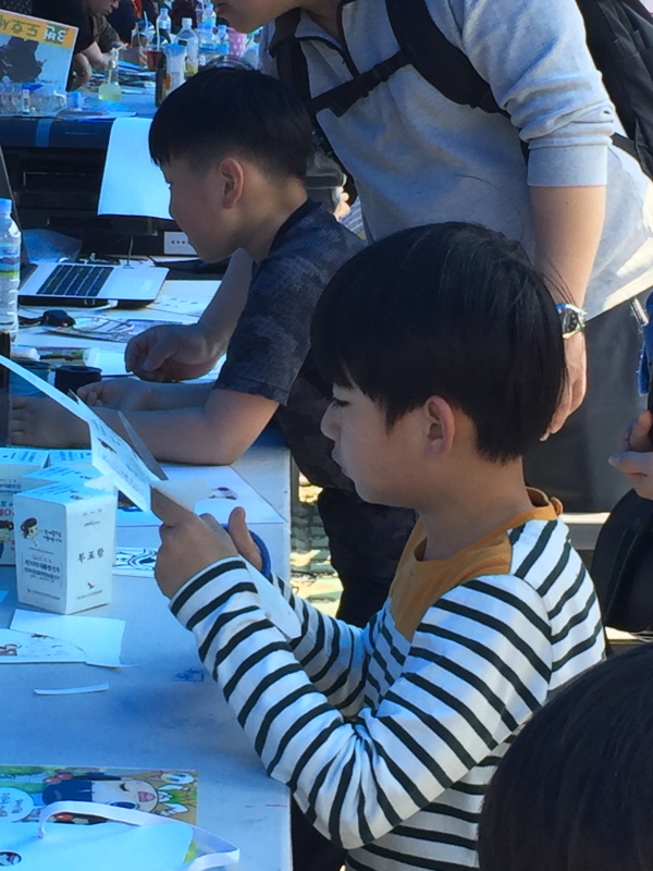 선거는 축제다 한옥마을 공예품 전시장에서 종이투표함을 만들고 있는 남자어린이